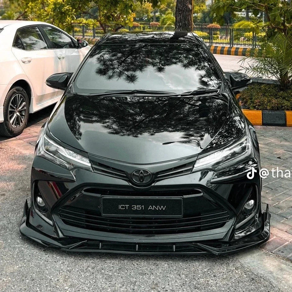 Black Toyota with aggressive front body kit and LED headlights, parked outdoors