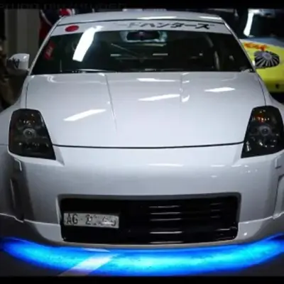 White sports car with blue underglow LED lights, custom body kit, and racing decals for car styling